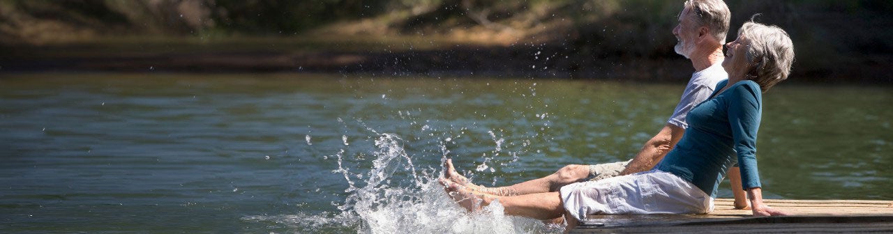 Senior couple sitting on dock.