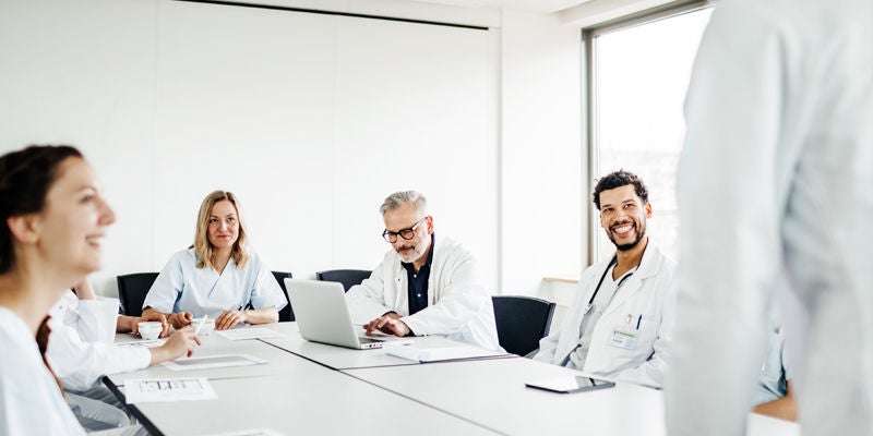 Physicians sitting in classroom style table.