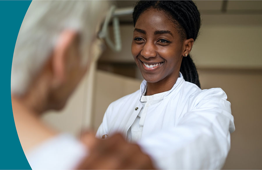 Woman physician smiling with patient.